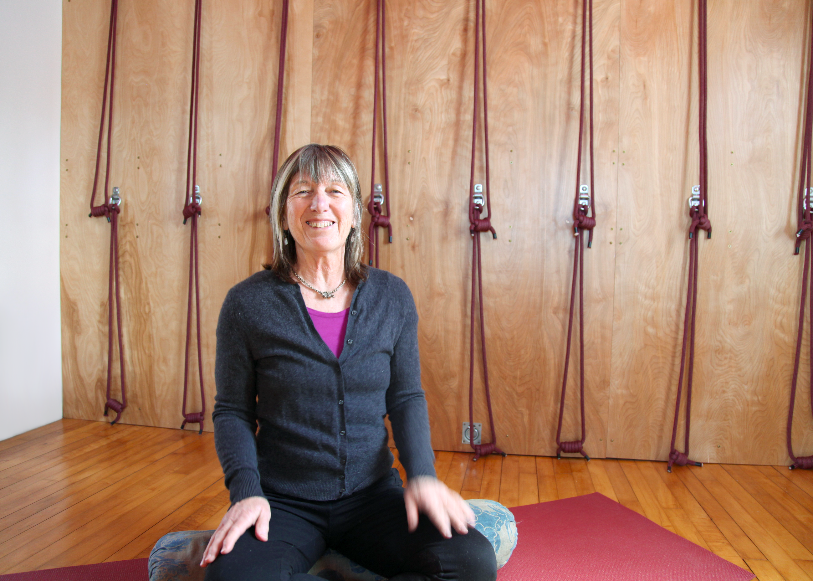 Teacher Lucinda sitting on a yoga mat